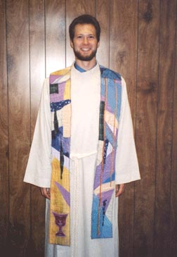 John Earl Cheadle dressed in alb and stole.   His fiance made the stole from pieces of material significant to John Earl throughout his life.