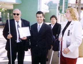 Don Burns presents a certificate of appreciation to Ryan Spencer, principal consultant from Assembly member John Dutra's office.   Federationist Joy Stigile and NFB-C President Nancy Burns look on.