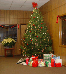A decorated Christmas tree stands in the fourth-floor reception area at the National Center for the Blind. Staff members place their packages for the gift exchange under the tree.