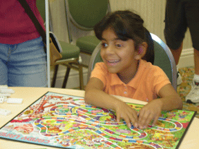 A little girl assembles a tactile puzzle at the Braille Carnival.