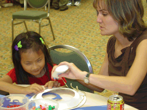 Angela Howard helps Ahbee Orton (TX) with a craft project.