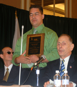 Eddie Bell poses with his plaque while Fred Schroeder (left) and David Ticchi (right) look on.