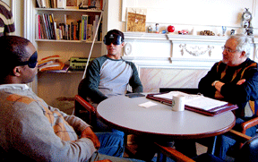 Dick Davis and his students discuss applying for jobs seated around a table in his office.