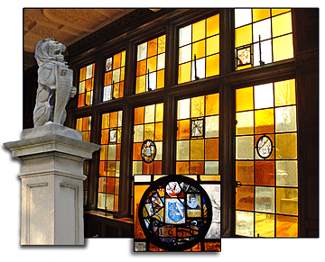 This is a leaded stained glass window in the lunchroom with embedded medallions. One of the medallions has been enlarged for clarity. It is dated 1636. Also shown here is a photo of one of the two lions that guard the mansion entrance from atop their pillars flanking the steps.