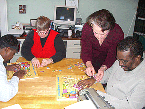 Sharon Monthei and Barbara Pierce help students assemble United States puzzles.