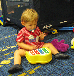 A little boy plays with a toy piano.