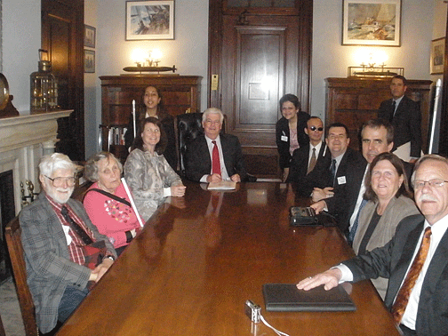 Seated at a table in the office of Senator Christopher Dodd of Connecticut from left to right are Jimmie Killian, Junerose Killian, Maryanne Melley, Senator Dodd, Fred Schroeder, Gary Allen, Jim McCarthy, NFB of Connecticut President Beth Rival, and Charlie Rival. Standing in the back are office intern, Deepa Goraya (NFB of California); NFB of Connecticut member, Carol Lemieux; and aide Jeremy Sharp.