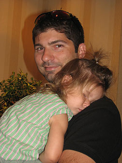 Convention can wear anyone out. At the end of a long day a toddler lies draped over her dad's shoulder.