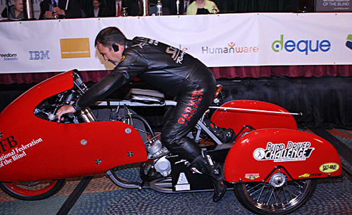 Dan Parker rides his three-wheel motorcycle to the edge of the stage.