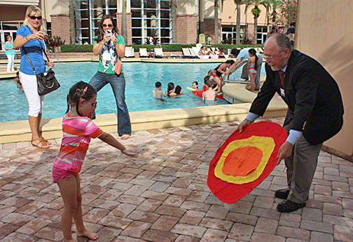Young girl takes aim at a large felt target, the last challenge in the Breaking Barriers Triathlon.