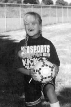 The picture is of a little girlin a soccer uniform, holding a soccer ball.