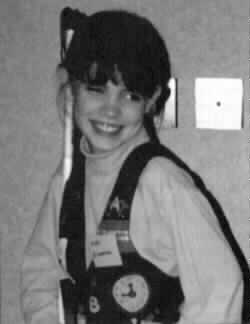 Picture of a smiling Nikki Zimmerman 
and her white cane.
