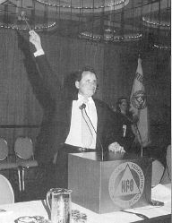 President Maurer shown holding the gavel over his head as he gavels the 1999 Conventin to order.