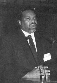 Picture of Wayne High, President of the NFB of Georgia, greeting convention delegates from
the podium.)