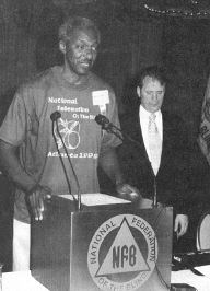 Al Falligan, NFB of Georgia Convention Coordinator, is shown preparing to introduce Representative
 Randy Suader. President Maurer looks on.