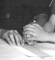 Picture of Joy working hand over hand, teaching Kirt how to control the stylus.
