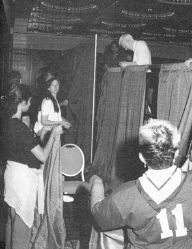 Staff members are taking down the platformcurtains at the close of the convention.