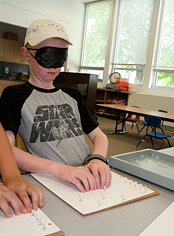 A boy wearing sleepshades practices tracking.