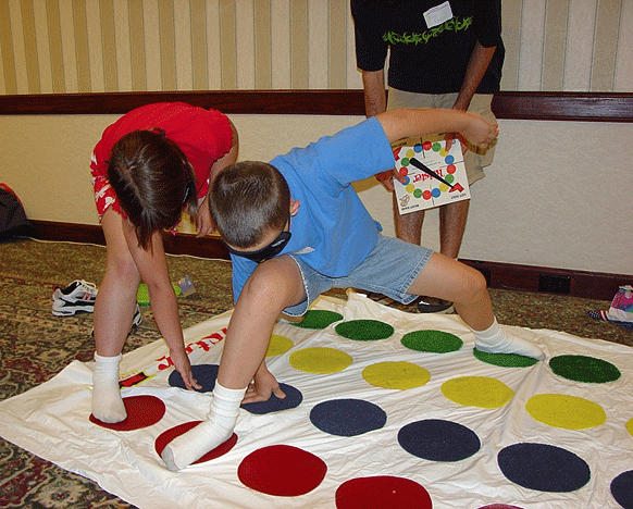 Two students wearing blindfolds play Twister on a modified tactile game board.