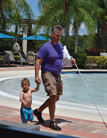 Jim Jackson walks with his son along the side of the pool. 