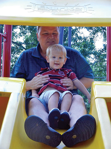 A father and his son have fun on the slide 