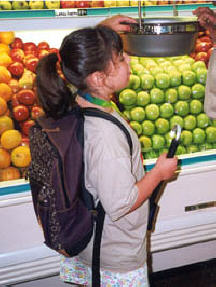 "What's this?" Jessica Woods examines the hanging scale in the produce department during a supermarket outing.