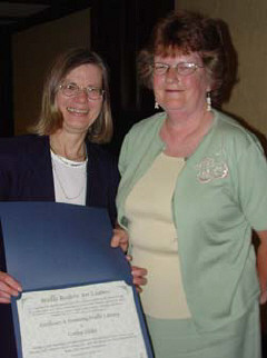During the celebration program, Barbara Cheadle, President of the NOPBC, presents Cathy Hicks, the Kentucky School for the Blind librarian, with the 2003 Braille Readers Are Leaders "Excellence in Promoting Literacy Award."   For twenty years, Hicks has enthusiatically promoted Braille Readers Are Leaders contest among the stidents and staff at the school.