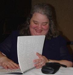Nadine Jacobson, president of the National Association to Promote the Use of Braille (NAPUB), reviews the Braille agenda before convening the anniversary program.  NAPUB, in partnership with the National Organization of Parents of Blind Children (NOPBC) estblished the Braille Readers Are Leaders contest in 1983.