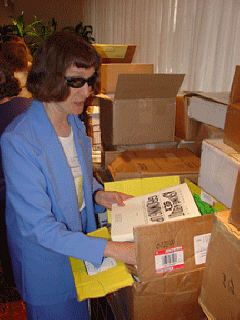 Barbara Loos, President of the American Action Fund (AAF) board, sets out Braille books donated by the AAF.  A former Braille instructor and long-time Braille advocate Loos also volunteered as a Braille Mentor at the reunion.