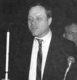 Image of Gary Wunder shown with his white cane and a microphone