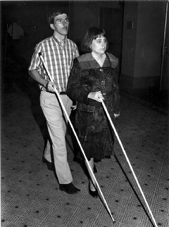 A blind person as a guide.