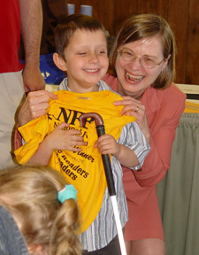Alexander Grigalus-Kern, a top-ten winner in the K-1 category, read over 1,100 pages. Here he poses with NOPBC president, Barbara Cheadle at the Maryland Braille Readers Are Leaders party. 