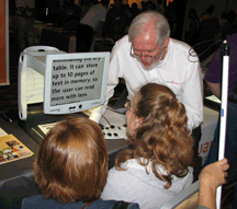 Kayleigh Joiner, age 15, and Kim Cunningham, (Texas), look on as Jim Halliday from HumanWare displays myReader� 600