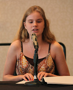 Reading from Braille notes at the microphone, Riley Robinson of Indiana speaks to parents and professionals about her experiences.