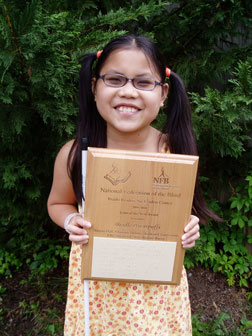 Ashleah Chamberlain proudly holding up her winner's plaque