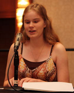 Rylie Robinson reads from Braille notes at a podium.