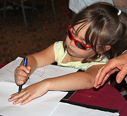 This young blind girl is intently drawing her work of art. 