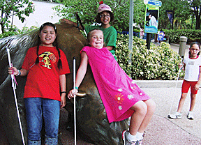 Torrie Franklin and a group of friends lean against a large statue at SeaWorld