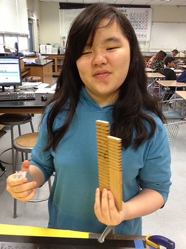 Cricket Bidleman holds the pieces of the Vernier scale that her physics teacher created.