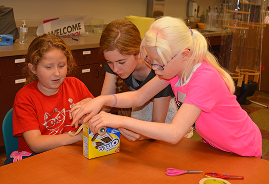 Kaylee Nielson helps Isabella Barnett and Ashlynn Dunn with their project during STEM2U 