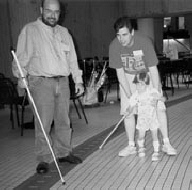 Joe Cutter gives a cane lesson to a parent and toddler at the National Federation of the Blind Convention.