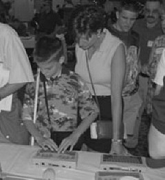Renee Brown and son John examine the newest Braille notewtakers at the 2001 exhibit hall.