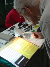 Senior man uses a magnifier to read