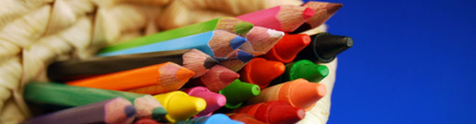 Lots of colorful crayons in a basket with a blue background.