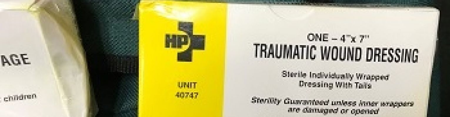 A box of bandages with print and Braille lettering sits on a backpack.