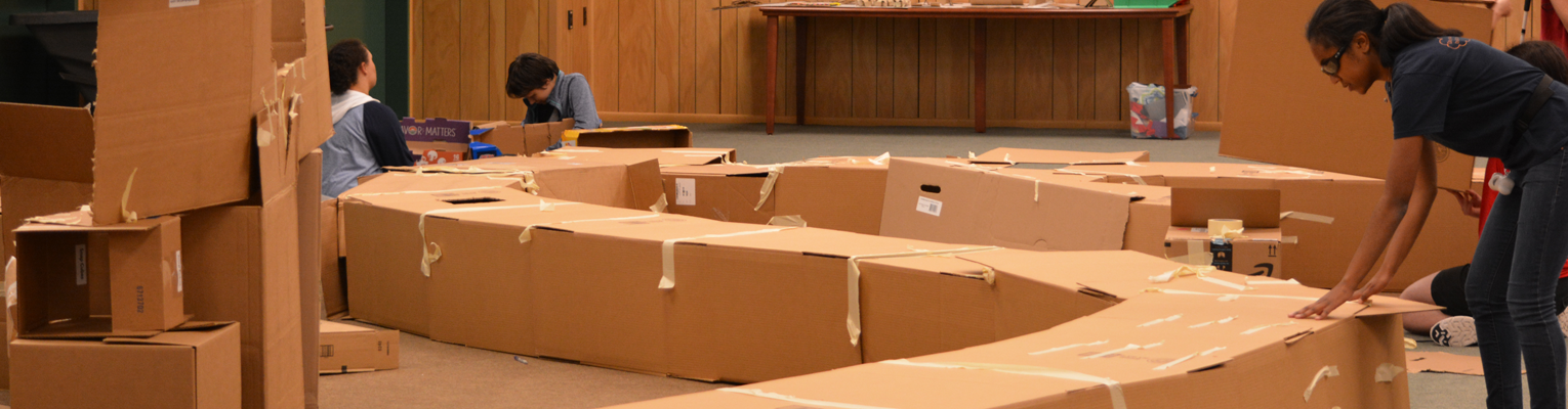 Students from one of our EQ programs build a tunnel out of cardboard boxes.