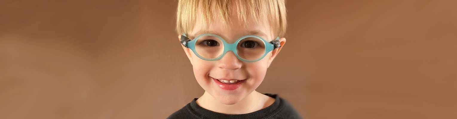 Kadyn wearing his blue glasses and smiling at the camera.