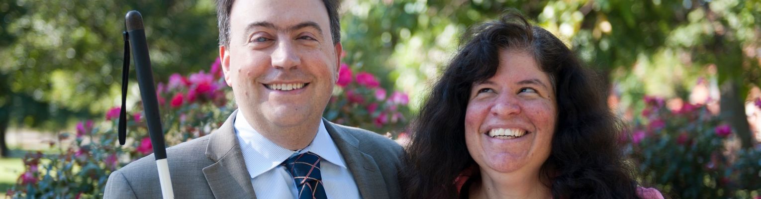 NFB President Mark A. Riccobono and First Lady Melissa Riccobono stand together smiling in the park.
