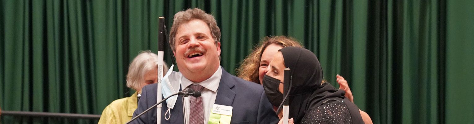 Scott LaBarre that the 2022 National Convention podium laughing with Ronza Othman