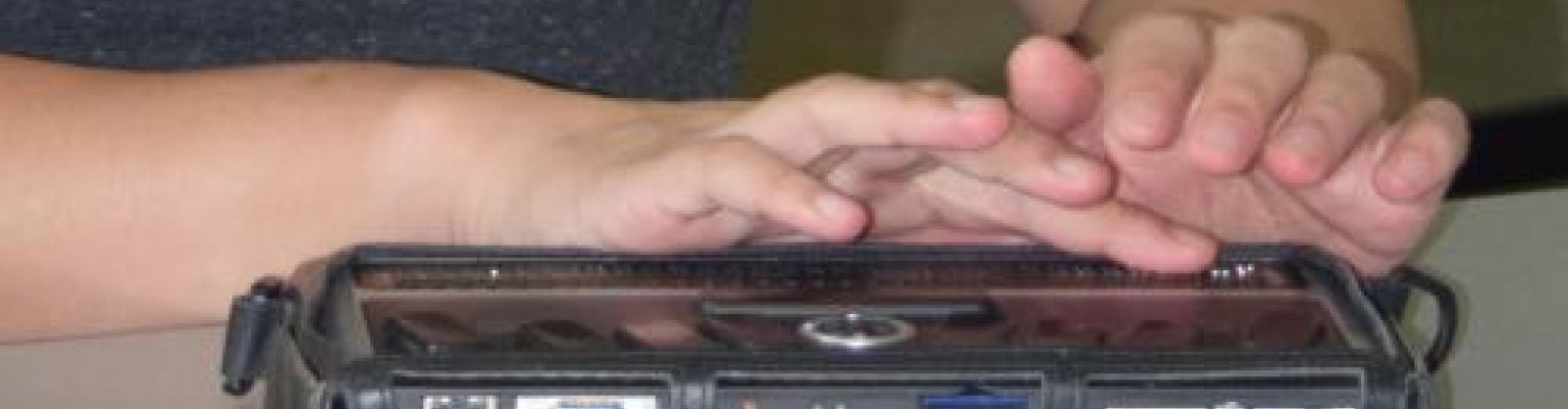 Close up of hands on a Braille display